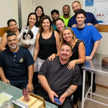 Equipe da Cãopacabana reunida na clínica, com um shih-tzu no colo